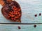 An open annatto berry , Urucumchestnut with seeds, isolated on a wooden table.