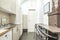 Open apartment kitchen with gloss cream cabinets, stainless