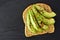 Open avocado sandwich with chia seeds on dark slate