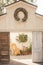 Open barn doors with wreath hanging at the top opening up to a wicker rocking chair