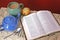 Open bible on table with vintage table cloth, teapot, mug and mu