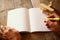 Open blank notebook and man hands next to toy aeroplane on wooden table. retro style filtered image