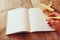 Open blank notebook and woman hands next to toy aeroplane on wooden table. retro style filtered image