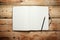 Open blank notepad laying on a wooden ta