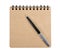 Open blank square notebook of brown kraft paper with a spiral and ballpoint pen lie on a white background