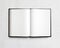 Open blank textbook on white stucco wall