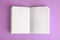 Open book with blank pages on violet background