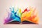 Open book with colorful rainbow paint splashes