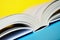 An open book or diary lies on a yellow and blue background. Close-up. Diagonal composition