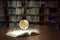 An open book glows brightly and reveals a globe of the world, in old self of book library university background among