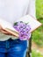 An open book in the hands of a young girl. Lilac branch on an open book. Reading. Girl in white clothes. Close up, copy space