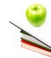 Open Book heap and green apple on top over white background. Con