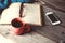 Open book with phone, glasses and coffee or tea top view on table