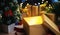Open Christmas Box Gift Besides Small Christmas Tree. Glowing Li