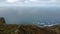 Open clear blue sky,Aerial overview above the mountainous coastline, small houses stretching along the coast, high point