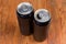 Open and closed black beverage cans on the rustic table