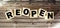 Open concept after the coronavirus pandemic. Wooden blocks with text REOPEN isolated on brown background