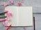 open diary and pencil pink flower on wood background