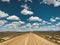 Open Dirt Road in the Country with Clouds and a Blue Sky