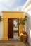 Open door Greek island of Rhodes, Lindos village, pot at the entrance and mosaic of pebbles traditional colorful white house