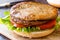Open Double Burger with Turkey Meat, Lettuce and Tomatoes on Wooden surface