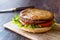 Open Double Burger with Turkey Meat, Lettuce and Tomatoes on Wooden surface