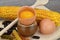 Open egg around corn, pasta and beans on a cutting board. Yolk and albumen.