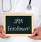 Open Enrollment - Doctor holding chalkboard with text