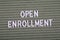 OPEN ENROLLMENT. White letters of the alphabet on a green background