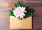 open envelope from kraft paper with peonies in it. minimal holiday concept, top view