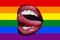 Open female mouth with tongue against the rainbow flag background, LGBT concept. Sexy tongue and lips in female mouth