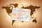 Open foreign passport with international visa stamps on ancient world map on old paper