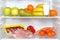 Open fridge full of fruits