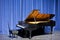 Open grand piano on stage with blue velvet cutain