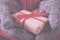 Open hands holding a present wrapped with a red ribbon Vintage R