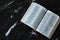 Open Holy Bible Book on black and white granite marble background