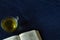 Open Holy Bible Book with a cup of yellow tea on blue granite background with copy space for text.