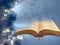 Open holy bible in clouds with sunburst rays light