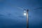 Open incandescent light bulb with old electric wire and gloomy sky at twilight,