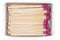 Open matchbox of wooden matches with purple heads, top view