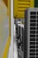 Open metal and yellow window shutter and air conditioner hanging