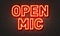 Open mic neon sign on brick wall background.