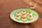 Open mini sandwiches on white bread with red caviar on a green plate on a brown concrete background. Snack recipes