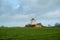 In the open nature in a field stands a windmill