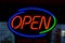 An OPEN neon sign at glowing at night at a restaurant