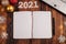 An open notebook on the table with Christmas decorations. Targets for 2021, empty space for entries. Plans and challenges for the