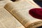 An open old Jewish book. Red knitted jewish bale lies on an open scripture page. Selective focus. Closeup of hebrew text