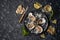 Open oysters lying on crushed ice with lemon, peppermint, with a knife for opening oysters on a dark textured stone background.