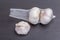 Open packaged white garlic bulbs in net place on wooden table, g