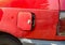 Open petrol cap on an old red car after successful theft of a gasoline or diesel fuel